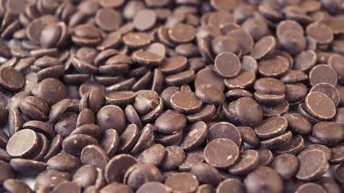 Chocolate Chips Drops Rotating Background. Food Concept.