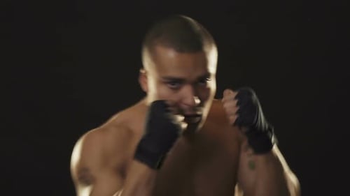 Young Handsome African Fighter Shadow Boxing on Black Background