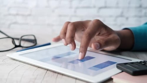 Man's Hand Working on Digital Tablet at Office Desk, Using Self Created Chart