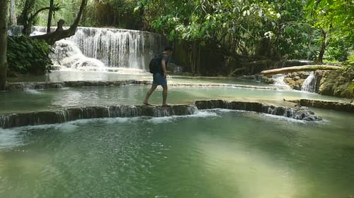 Young Adult Exploring Tropical Waterfall Oasis