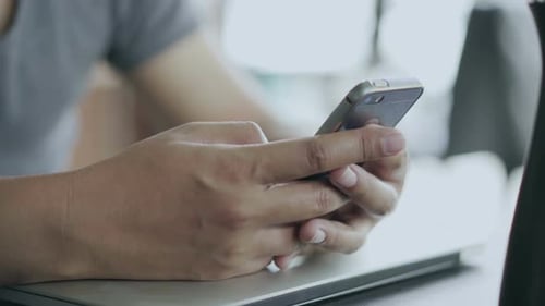 man using smartphone in cafe