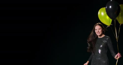 Woman Dances With Balloons in Dark Setting