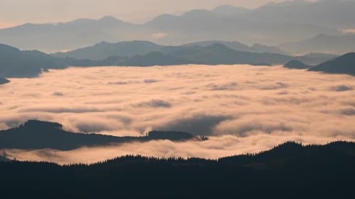 Golden Fog Shimmers Between Mountain Peaks at Sunrise