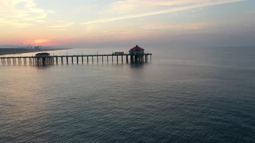 A stunning 4k parallax view of beautiful beachfront luxury hotels as seen through the pier at sunris