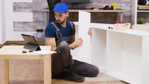 Travailleur de sexe masculin en salopette avec un assemblage de casquette une étagère