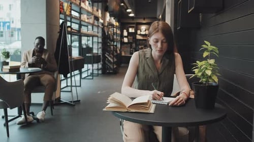 Porträt einer jungen Frau, die in der Bibliothek studiert