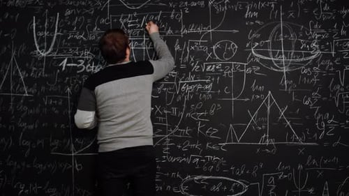 Man Writes Formula on Chalkboard Full of Algebra Equations and Smiles Crossing Hands