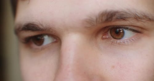 Extreme Nahaufnahme des menschlichen Auges. Der Bildschirm spiegelt sich in den Augen, die Beleuchtung des Geräts leuchtet.