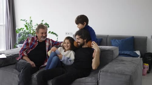Family Gathers on Couch Smiling and Laughing