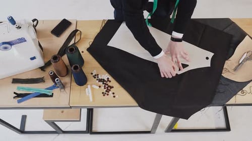 Modedesigner oder Schneiderei macht ein Muster auf einem braunen Stück Taschentuch