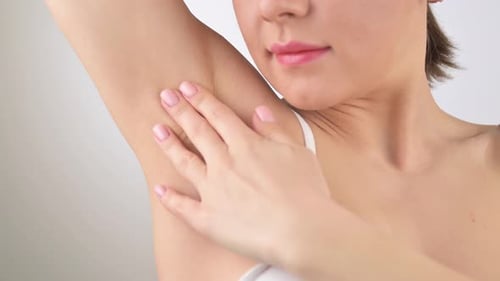 Woman Applies Lotion to Armpit for Beauty Care