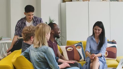 Diverse Group Brainstorming on Couch Indoors