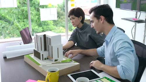 Business people design building model