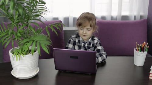 Little Girl Learning on a Laptop at Home
