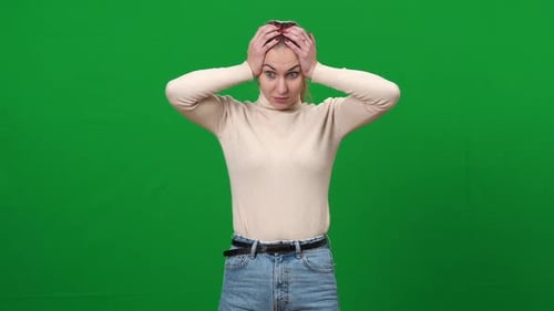Woman Rubbing Temples Against Green Screen