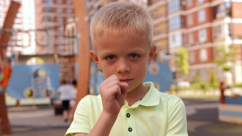 A Little Boy on a Modern Playground Playing the Game Rock Paper Scissors