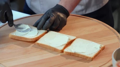 Close Up of Man in Gloves Applying Spread on Bread