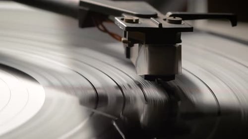 Dropping Stylus Needle On Vinyl Record Playing With Disc Rotating Close Up. Old dusty turntable.