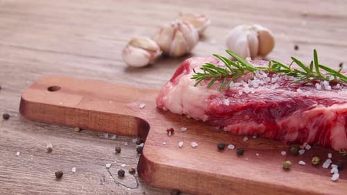 Raw Steak Garnished With Rosemary and Tomatoes