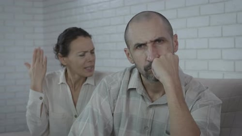 Couple Arguing in Front of a White Brick Wall
