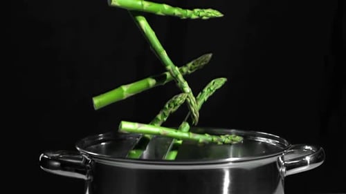 Fresh Asparagus Falling into Pot of Water