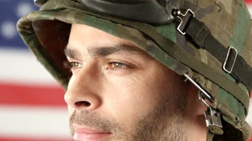 Soldier standing in front of American flag