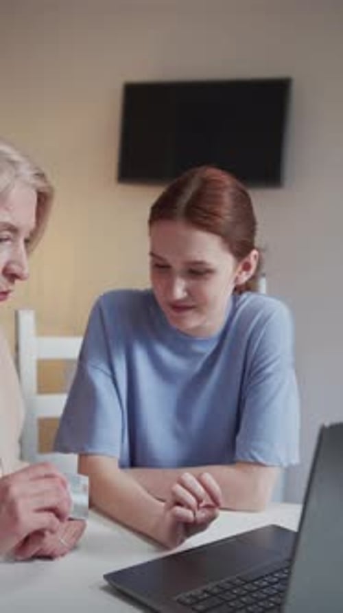 Senior Woman and Young Adult Using Computer