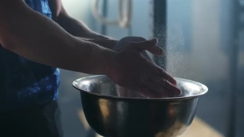 Man Prepares for Fitness with Chalk at Gym