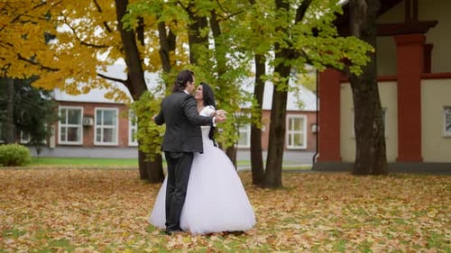 Bride and Groom Dancing in Autumn Leaves