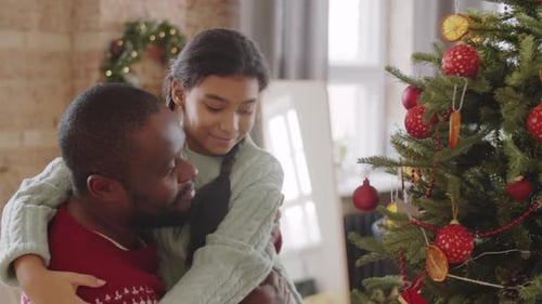 Father and Daughter Decorating Christmas Tree Together