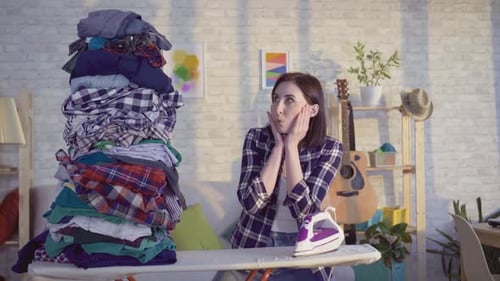 Woman Looks at Tall Pile of Laundry