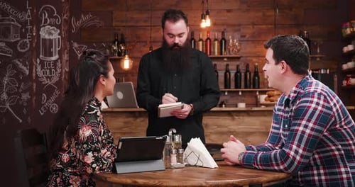 Couple Ordering Food at Rustic Restaurant Table