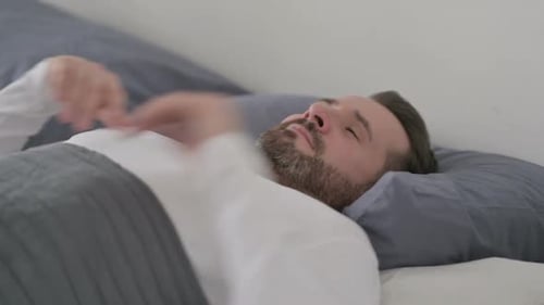 Homme se réveillant de son sommeil au lit