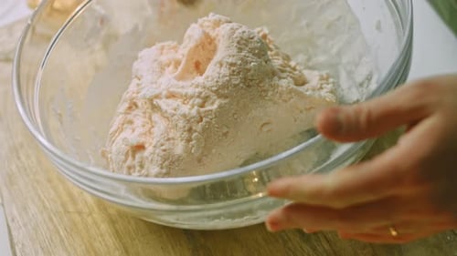 Person Kneading Dough in Glass Bowl