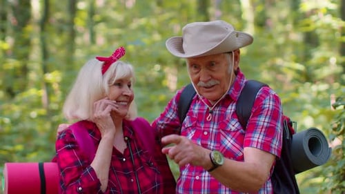 Senior Couple Hiking Together in Green Forest