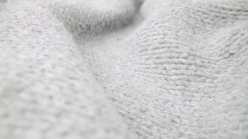 Extreme detail view of sheep wool cloth texture flowing in macro dolly shot.