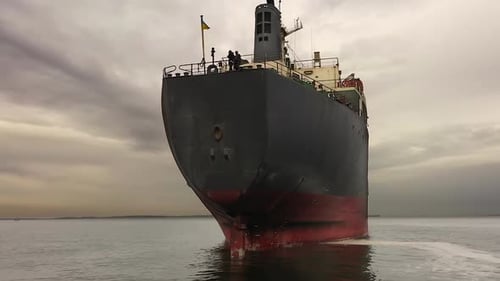Cargo Ship Sailing Across Calm Blue Sea