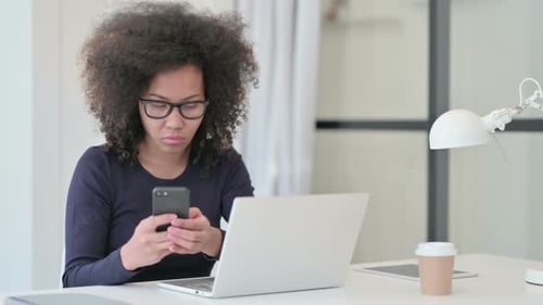 Young Adult Using Smartphone at Desk
