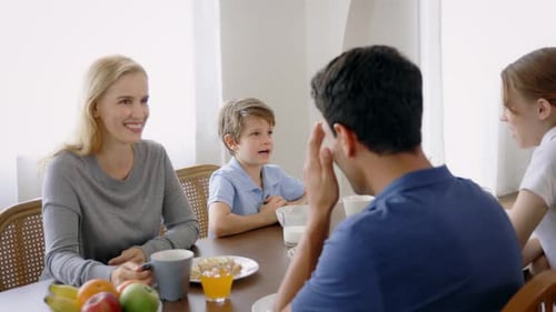 Family Enjoying Breakfast Together at Home Around Table