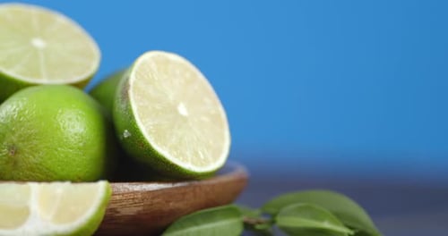Close Up Shot of Limes in Wooden Bowl