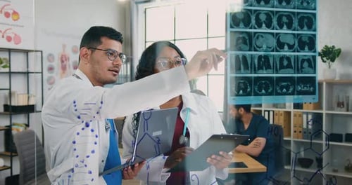 Männliche und weibliche Mediziner arbeiten mit Röntgen-Scan in einer Arztpraxis im Hintergrund