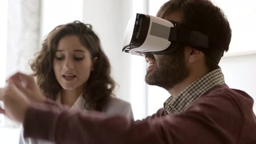 Vista lateral de un joven con auriculares de realidad virtual