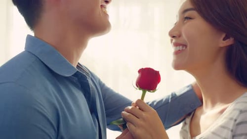 Man Gives Rose to Woman, Kisses Her Forehead
