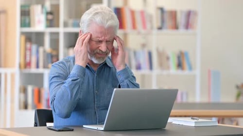 Senior Man Experiencing Headache While Using Laptop