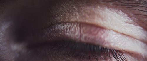 Close up of a beautiful ice blue eye closing and opening
