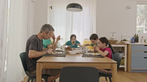 Family Enjoys Meal Together at Dining Table