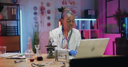 Woman Scientist Works on Laptop in Lab Office