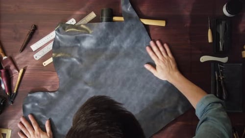 Leatherworker Smoothing Leather at Workbench with Tools