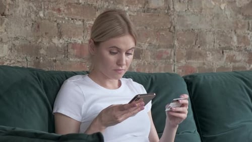 Online banking with smart phone. Woman buys online shopping at home with credit card and smartphone