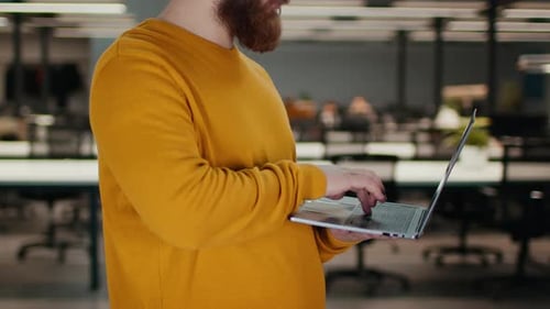 Unrecognizable Man Using Laptop Computer Working Standing In Spacious Office